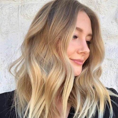 Woman with blonde hair posing outside showing new hair for Color-safe hair care tips